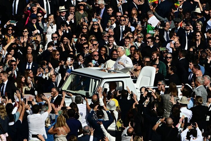 Pope Leo XIV waves from the popemobile