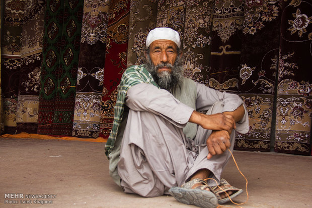 پوشش لباس سنتی و محلی مرد زابلی و فروشنده فرش در بازار زابل