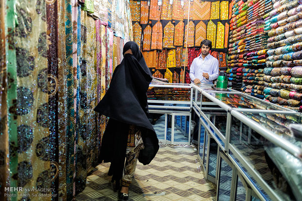 زن جوانی که برای خرید پارچه و لباس به بازار محلی زابل آمده است چهره خود را از دوربین مخفی می کند، حضور زنان و دختران جوان در جوامع عمومی کمتر قابل رویت است .