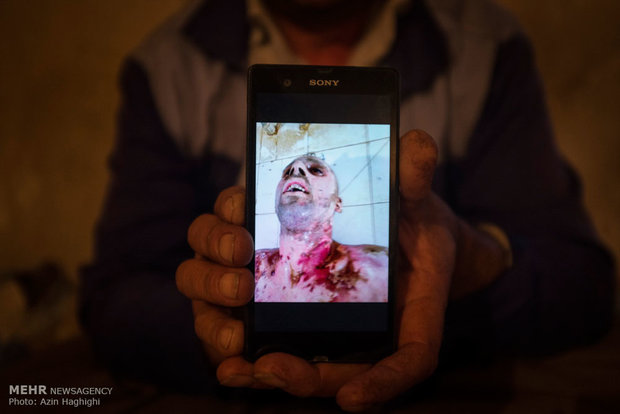 یکی از کارگران معدن جوزچال استان گلستان عکس همکارش را که در انفجار آتشبار فوت شده بود به عکاس نشان میدهد.