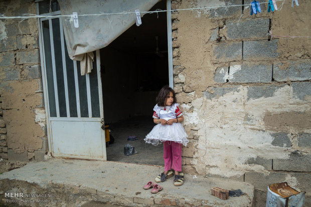 دختری با لباس عروس کنار در خانه شان در روستای کلاسر واقع در شرق استان گلستان ایستاده است. دختران کوچک علاقه زیادی به پوشیدن لباس عروس در سنین خردسالی دارند و با پوشیدن لباس عروس در رویاهای خود به بازی زندگی می پردازند