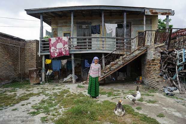 یک زن ترکمن که دچار اختلال حواس می باشد در مقابل منزل خویش در روستای خواجه نفس ایستاده است.
