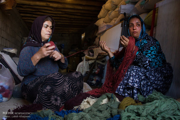 زنان در حال کلاف کردن نخ های قالی در انبار خانه