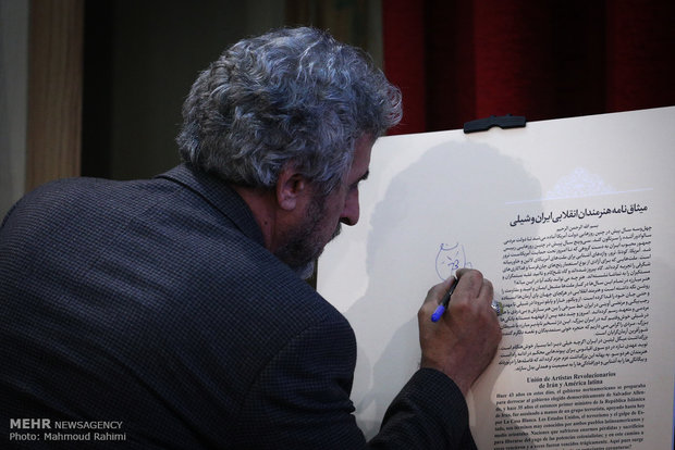 مسعود جعفری جوزانی در حال امضا میثاق نامه هنرمندان انقلاب اسلامی در مراسم تجلیل از میگل لیتین فیلمساز شیلیایی 