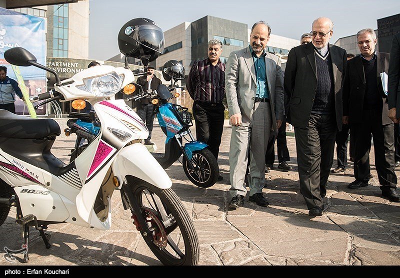 Deputy environment chief Saeed Motesaddi (C) and Industry Minister Mohammadreza Ne’matzadeh (R) are seeing two electric motorcycles showcased on the sidelines of the conference.