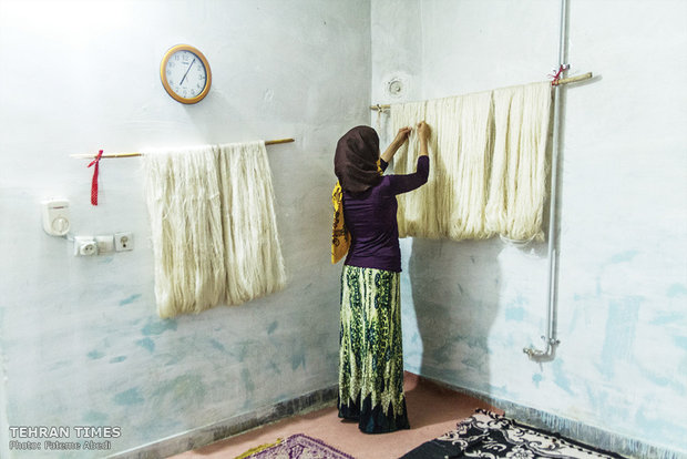 Zeinab, 18, is hanging the wet silk thread to dry. 