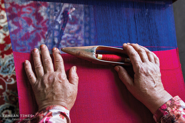 A woman is weaving a silk cloth.