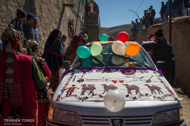 The guests gather around the wedding car which is decorated with traditional Turkmen textile and colorful balloons.