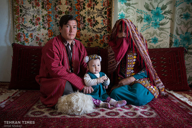  A newly-wed Turkmen couple pose for a photo with a little child. They believe that cuddling a little child during the wedding ceremony would lead to their childbearing. 