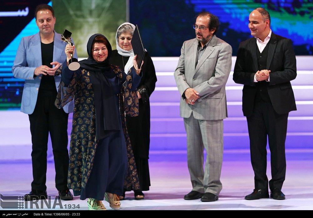 Director Puran Derkhshandeh accepts the award for best film for her drama “Under the Smoky Roof” during the 2nd Health Film Festival in Tehran at Vahdat Hall on August 27, 2017. Jury members are also
