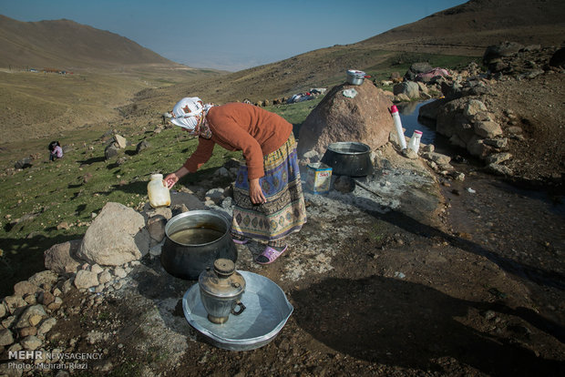 زن عشایر در حال شستشوی ظروف و البسه در کنار رودخانه 