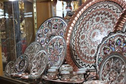 A shop window displays handcrafted metalwork by Iranian artisans