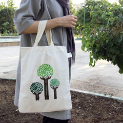 A woman is holding a cloth bag as an eco-friendly alternative to plastic bags 