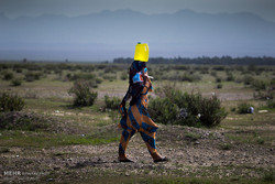 A woman is carrying a gallon of water on her head taken from a well located outside a village in the southwestern province of Kerman in May 2017. People in drought-stricken areas should sometimes walk a fairly long distance to obtain potable water for everyday use. (Photo by Vahid Abdi/Tehran Times)