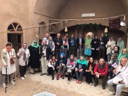 International travelers pose for a photo during their visit to a traditional house in Ardakan. 