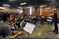 Ali-Akbar Qorbani conducts an orchestra performing traditional Iranian instruments during a rehearsal at Tehran’s Rudaki Hall on June 24, 2018. (Honaronline/Mahdieh Babai)  