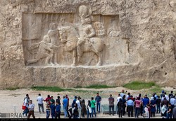 People visit a Sassanid-era bas-relief carving in Naqsh-e Rustam, an ancient necropolis near Persepolis in Fars province, southern Iran.