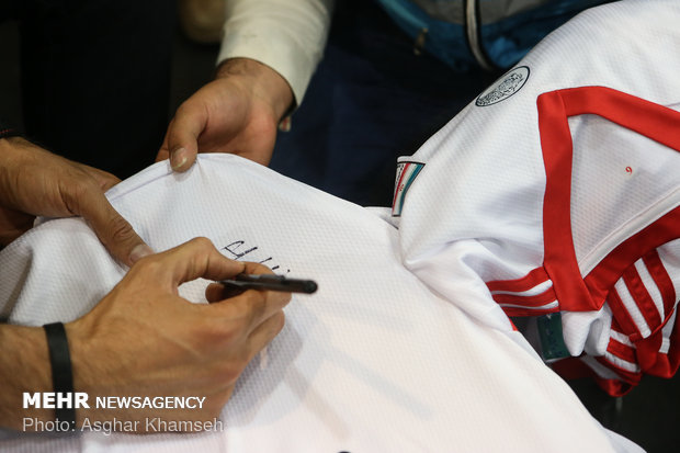 Iran's goal keeper watches World Cup final with teen workers