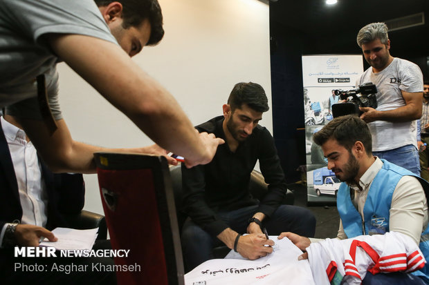 Iran's goal keeper watches World Cup final with teen workers