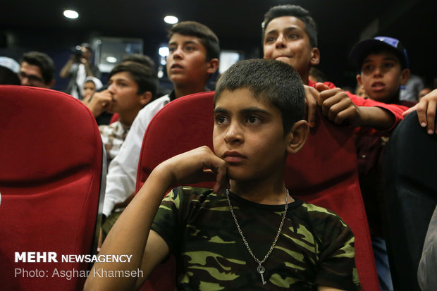 Iran's goal keeper watches World Cup final with teen workers