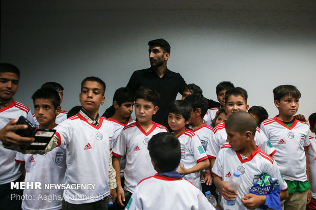 Iran's goal keeper watches World Cup final with teen workers