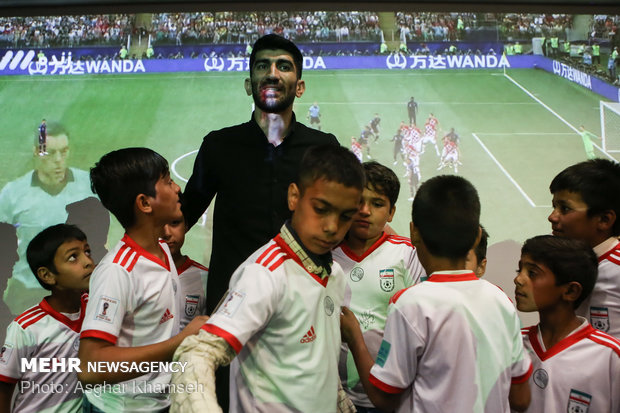 Iran's goal keeper watches World Cup final with teen workers