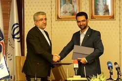 ICT minister Mohammad Javad Azari Jahromi (r) shakes hand with energy minister Reza Ardakanian after signing an agreement on Tuesday