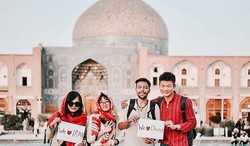 Iranian and Chinese nationals pose for a photo in the UNESCO-registered Imam Square of Isfahan, central Iran. The picture depicts Safavid-era Sheikh Lotfollah Mosque in the background