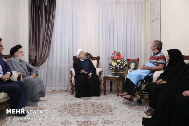 Rouhani visits families of martyrs, war veteran