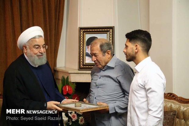 Rouhani visits families of martyrs, war veteran