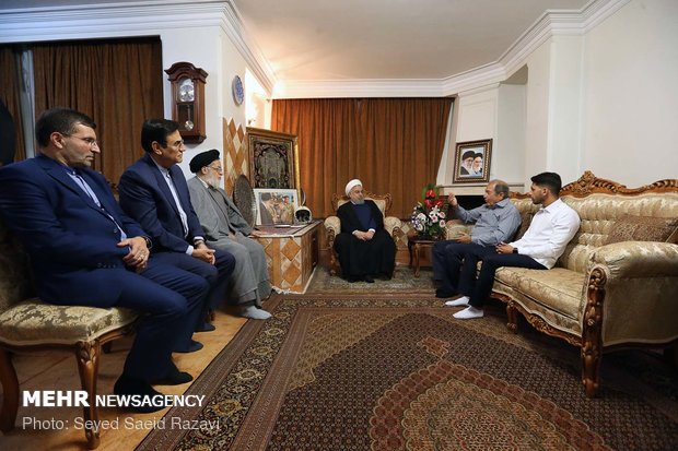 Rouhani visits families of martyrs, war veteran