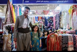 Kurdish exhibitors pose for a photo in front of their stand on the opening day of the 30th National Crafts Exhibition at the Tehran Permanent International Fairground, August 25, 2018.