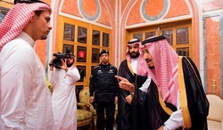 Saudi King Salman, right, points to Salah, a son of Jamal Khashoggi as Crown Prince Mohammed bin Salman, second right, looks on, in Riyadh, Saudi Arabia, Oct. 23, 2018.