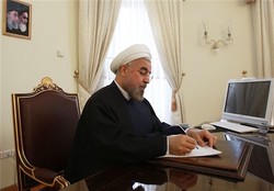 President Hassan Rouhani writes a letter in an undated photo.
