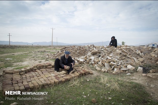 پدر پروین در حال جدا کردن آجرهاست تا راحت تر بتوانند خاک ها را جست جو کنند