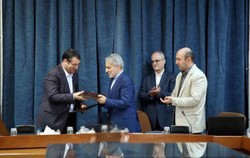 Industry Minister Reza Rahmani (L) and Mohammad Baqer Nobakht, the head of MPO, exchanging the documents of an MOU they signed on job creation co-op on Tuesday