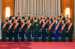 President Xi Jinping, also chairman of the Central Military Commission, takes a group photo with representatives from model units and model personnel before a Central Military Commission meeting in Beijing on Friday.