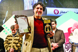 Director Mohammad-Taqi Rahmati holds the Golden Lantern for Best Documentary on Economic War for his “In the Name of Father” during the 9th Ammar Popular Film Festival at Tehran’s Felestin Cinema on J
