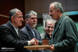 Scholar Abdolhossein Azarang (R) shakes hands with Tehran City Council member Ahmad Masjed-Jamei
