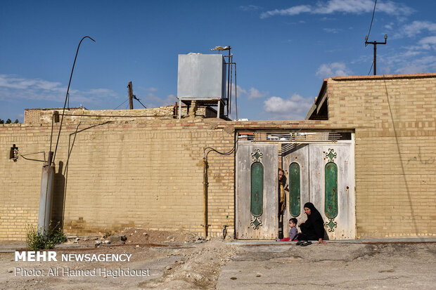 خانم سکینه احمد پور (نشسته، راست) و فروزان صالحی در مقابل خانه خود در محله کلگه ایستاده اند. آنها از نابسامانی و مشکلات این محله گلایه میکردند.