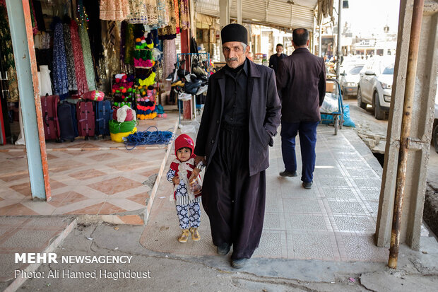 مرد بختیاری و نوه اش در بخشی از بازار شهر مسجد سلیمان دیده می شوند.