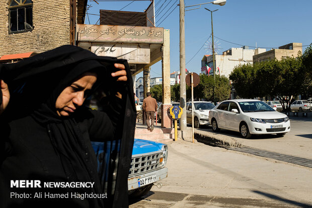 زنی در حال عبور از یک خیابان در مرکز شهر مسجد سلیمان است.
