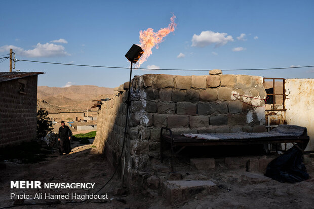 کاظم سلطانی در حال عبور از کوچه ای در روستای نفت سفید می باشد. یکی از نشانه های این روستا مشعل های برافروخته ایست که شبانه روز در آن روشن است.