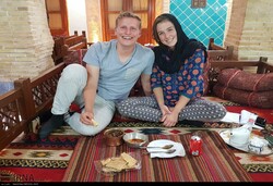 An international couple pose for a photo while staying in a traditional eco-lodge in Iran.