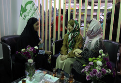 An IIDCYA staff (L) speaks to Kodansha representatives during the 32nd Tehran International Book Fair.