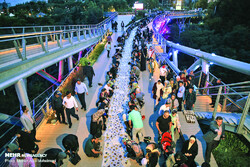 Hundreds gather on sculptural bridge for Ramadan meal
