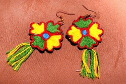 A pair of earrings richly ornamented with needlework