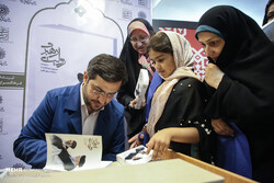 Writer Seyyed Yasser Jebraili autographs a copy “The Story of Leadership” after a meeting held at Tehran’s Andisheh Cultural Center on July 7, 2019 to introduce the book. (Mehr/Mahmud Rahim)