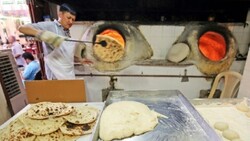 A baker bakes Iranian bread - known as taftoon - in Kuwait City in traditional clay ovens. Once ready he uses a long stick to reach in and pull out a steaming round loaf (Photo: AFP)