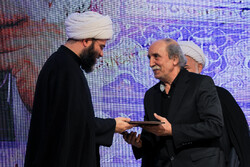 An unidentified winner receives his award from IIDO director Hojjatoleslam Mohammad Qomi during the Dibil Khuzai Awards – Ashura Book of the Year at the House of Humanities Thinkers in Tehran on Septe